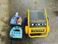 DeWALT portable electric air compressor and two new air hoses on ground.