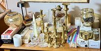 Full tabletop display of candlesticks, candles, and candle accessories.