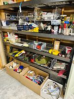 Wide shot showing multiple shelves filled with baskets and boxes containing assorted home improvement and tool parts and supplies