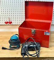 All items in lot displayed together, including the red metal case (open), Makita finishing sander, and Sears paint peeler.