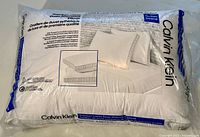 Sealed package showing Calvin Klein branding and pillow illustration with recommended bed size.