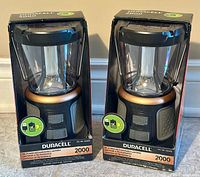 Two Duracell 2000 Lumens Tri-Power rechargeable lanterns in original packaging standing upright.