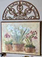 Photo showing both the metal wall hanger and the floral picture hung above one another on the wall.