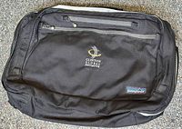 Front view of black Patagonia Transport shoulder bag with Clinton Global Initiative logo in white and gold embroidery on front zippered pocket, Patagonia label near bottom corner.