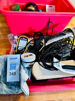 Pink plastic bins containing shoe shine kit materials including brushes, polish tins, cloths, and laces.