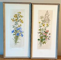 Pair of framed floral prints side by side on wall; left has glass, right missing glass