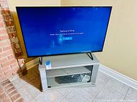Front view of TV mounted on grey stand in room