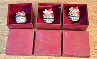 Three Villeroy & Boch ceramic Christmas trinket boxes in original red boxes with velvet lining, displayed on wooden surface.