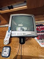 Front view of the Toshiba CRT television mounted with a matching wall mount showing the curved glass screen and front control buttons.