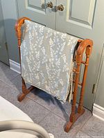 Full photo of the wooden quilt stand with the blanket draped over it, showing overall condition and appearance.