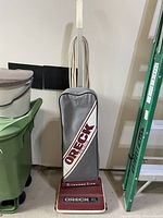 Full view of Oreck upright vacuum cleaner with cloth bag and power cord wrapped.