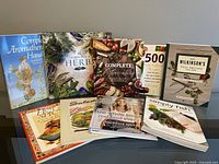 Photo showing front covers of 9 cookbooks and wellness books in a mixed set, with titles visible.