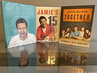 All three hardcover Jamie Oliver cookbooks standing upright with front covers visible.
