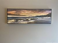 Frontal view of the horizontal framed seascape artwork hung on a grey wall.