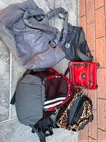 All five assorted bags positioned together on stone steps with a brick wall background