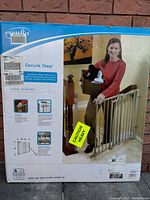 Box front showing Evenflo Secure Step safety gate, indicating hardware mount metal gate for doorways or hallway mounts, 30 inches height, fits openings 29 to 42 inches, with 'caution heavy' label.