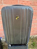 Black Heys SpinLite carry-on suitcase with textured hard shell and logo badge on front.