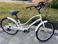 Side profile of white Sims Seabreeze cruiser bicycle with purple rims and chain guard.
