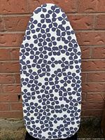 Photo of the ironing board's front side showing the white fabric cover with navy blue spot pattern covering entire surface.
