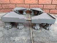 Universal adjustable base stand assembled on floor, showing sturdy legs and textured top surface.