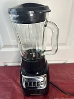 Front view of Black and Decker blender showing clear glass jar and control panel with push buttons on black base.