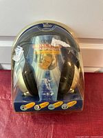Front view of Coby CV-320 digital stereo headphones in original clear plastic packaging with printed cardboard insert showing model and selling points.
