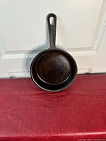Top view of the black cast iron skillet, showing the cooking surface with some light rust.