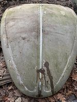 Top-down view of faded green Volkswagen Beetle hood showing discoloration, stains, and vertical center trim.