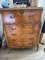 Front view of entire antique carved dresser with drop-front top and four drawers