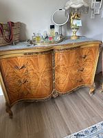 Front view of serpentine dresser showing wood veneer, carved trim and drawer pulls