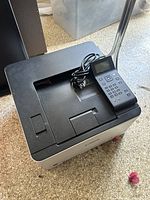 Front angled view of the Canon Color ImageCLASS printer with attached control panel and power cord placed on top.