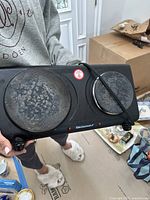 Photo of a black Elite Gourmet electric stove with two burners, showing surface wear and connected power cord