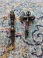 Both brass ritual items side by side on patterned carpet