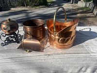 Overview of all items including copper pot on iron stand, large bucket, smaller decorated pot, and ash shovel.