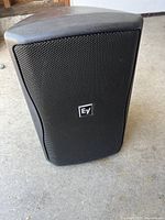 Front view of Electro-Voice speaker with metal grille and EV logo visible.