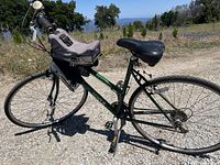Left side view of the green Mongoose cross bike with the front child carrier attached.
