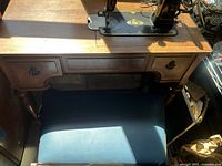 Wooden sewing table with two drawers and upholstered bench underneath