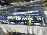 Box showing brand Sun Blaze, model T5 High Output fluorescent grow light fixture with 40,000 lumens, sealed in packaging with straps.