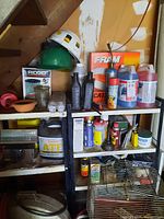 Metal shelving with multiple automotive fluids and oil filter boxes, including Ridgid oil filter box, bottles of oils, and Fram air filter box.