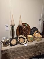 Photo showing the full lot on stone shelf including candlesticks, wooden wall hanging, woven baskets, humidity gauges, and thermometer