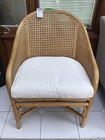Front view of the rattan chair with white upholstered seat cushion in place