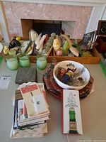 Wide view of lot showing Christmas place cards, green glass candle holders, assorted candles, decorative plates, coasters, and ceramic bowl with holiday items.