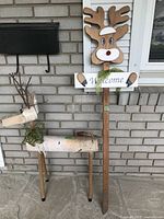 Photo of rustic wooden reindeer lawn figure with birch log body, twig antlers, and moss detail