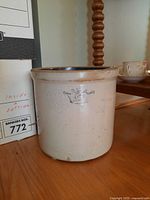 Front and side view of vintage stoneware crock showing crown emblem and interior
