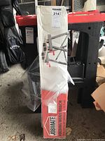 Jobmate folding work bench box, standing upright wrapped in plastic with product image and red, white packaging.