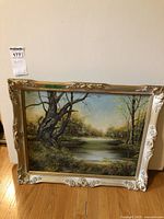 Framed landscape painting showing full scene and ornate frame.
