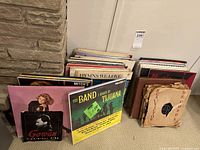 Overview of the stacked vinyl records showing a variety of album covers and vintage 78 rpm record sleeves