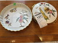 Top view showing quiche pan with peach and other fruit designs and covered vegetable bowl with corn design and gold handles.