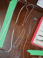 Top view of sterling silver chains and bracelets laid on wood surface