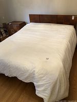 Full white synthetic duvet spread out on a bed, showing size and overall appearance.